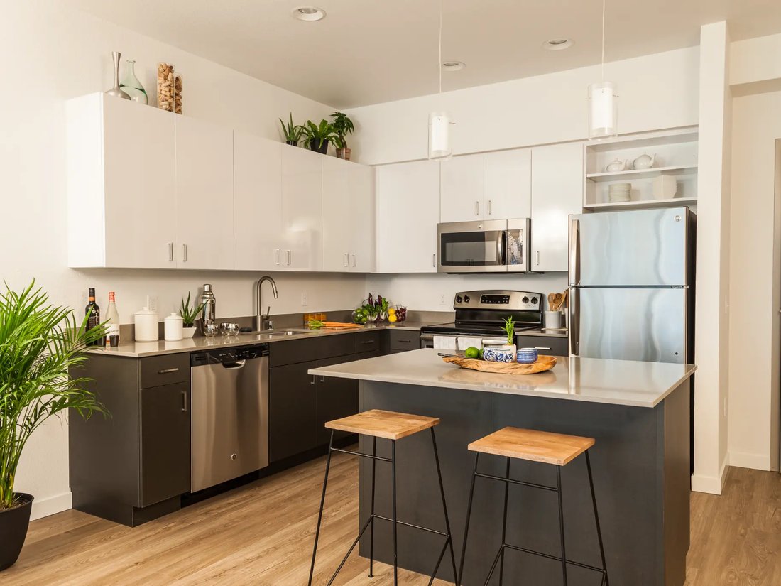 Bright white Oʻahu kitchen with a spotless island, stools and stainless appliances